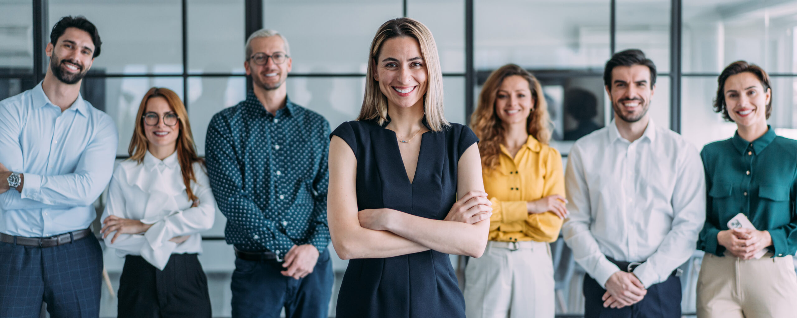 Diverse Gruppe von Menschen in einem Startup-Büro, Porträt mit Lächeln, Unterstützung und Kreativität in einem modernen Arbeitsumfeld. Frauen und Männer im Team, Zusammenhalt und Teambuilding.  Ausdruck von Zusammenarbeit im Unternehmen.